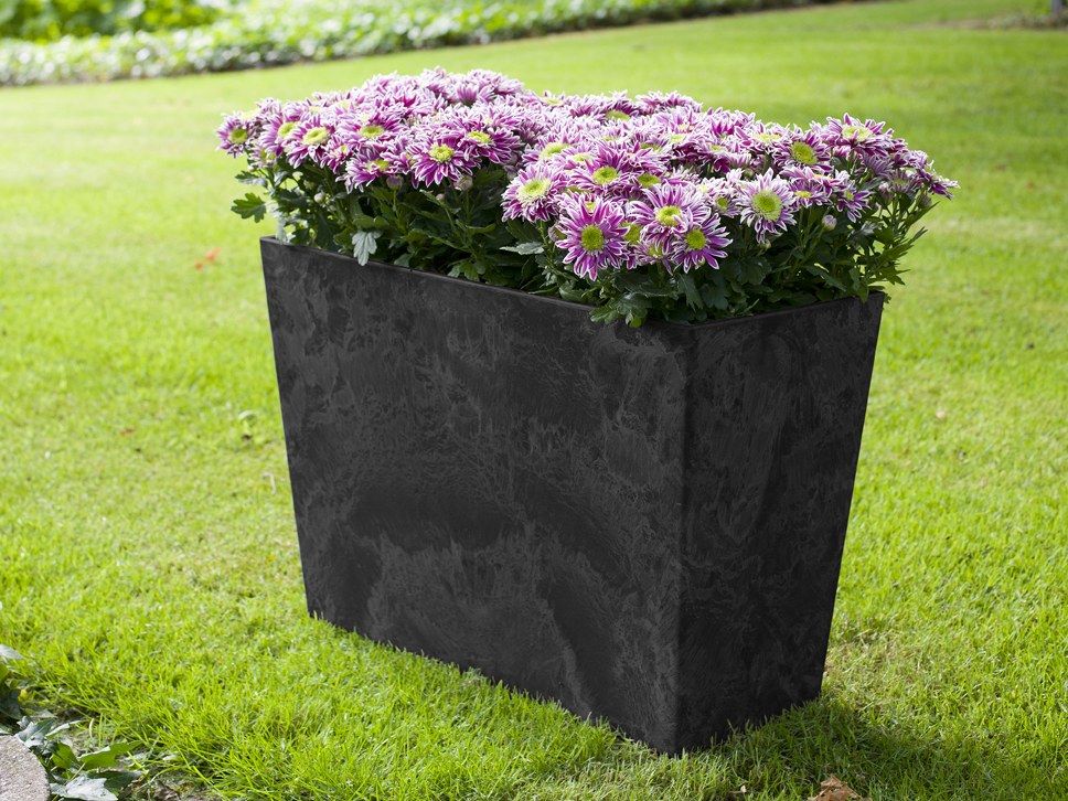 Schwarzer Artstone-Ella-Divider auf einer Rasenfläche, dicht mit rosa-violett blühenden Pflanzen bepflanzt