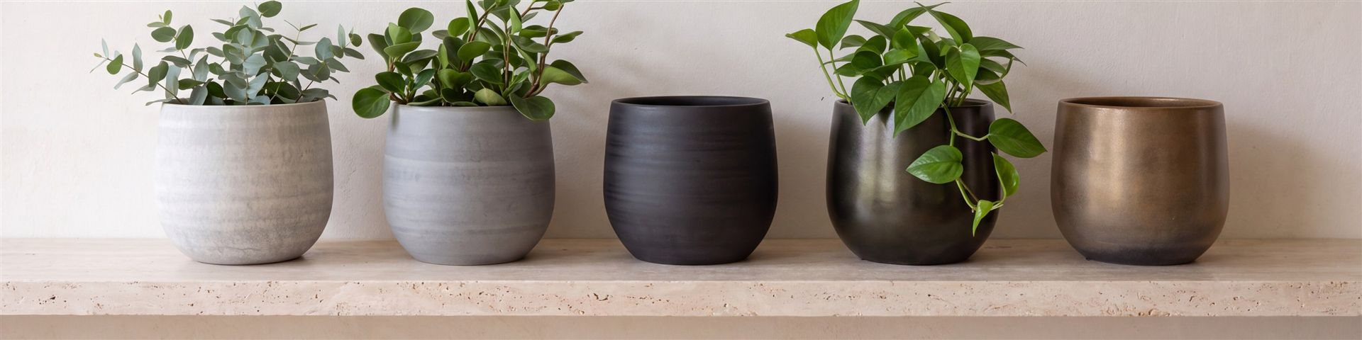 F&uuml;nf runde Esra-&Uuml;bert&ouml;pfe in concrete, mystic grey, graphite, shiny green und champagne auf einem hellen Regalbrett